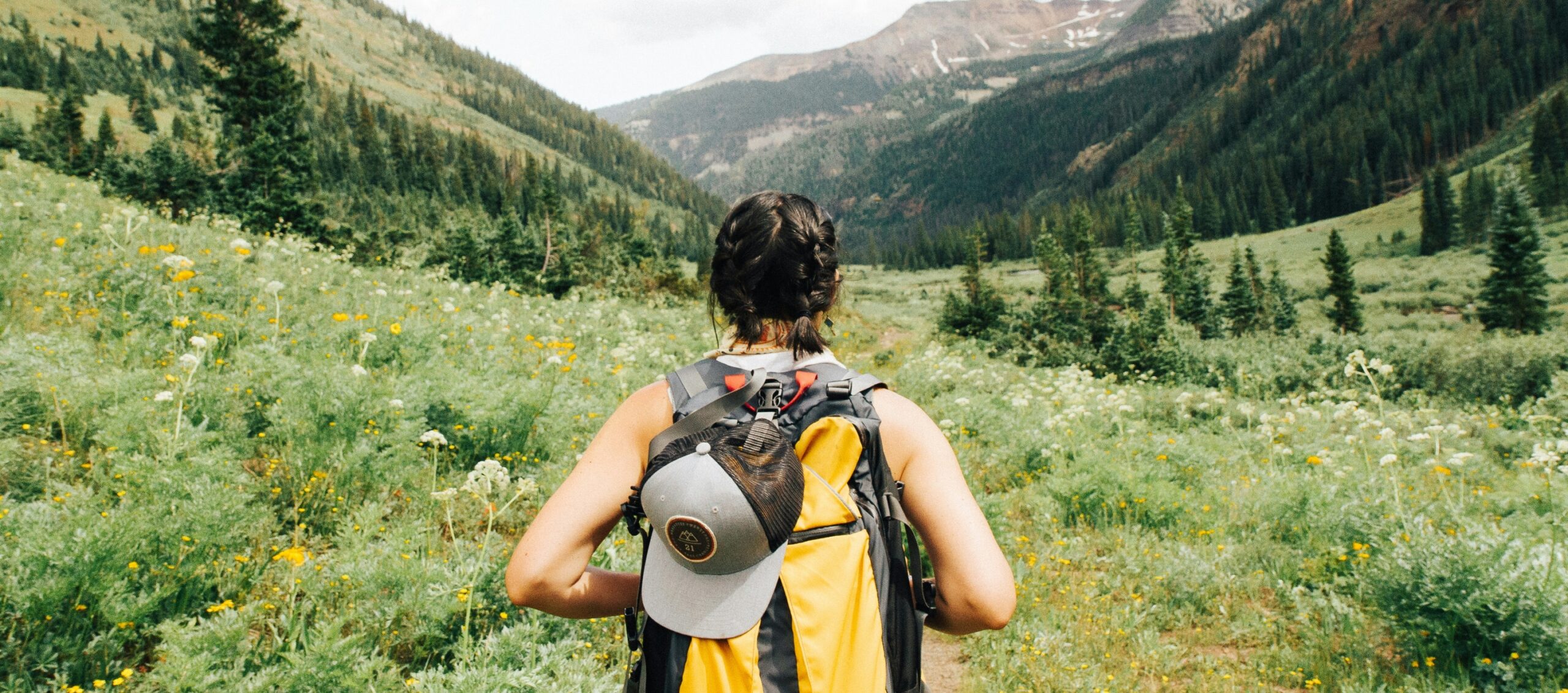 Girl hiking through wildflowers